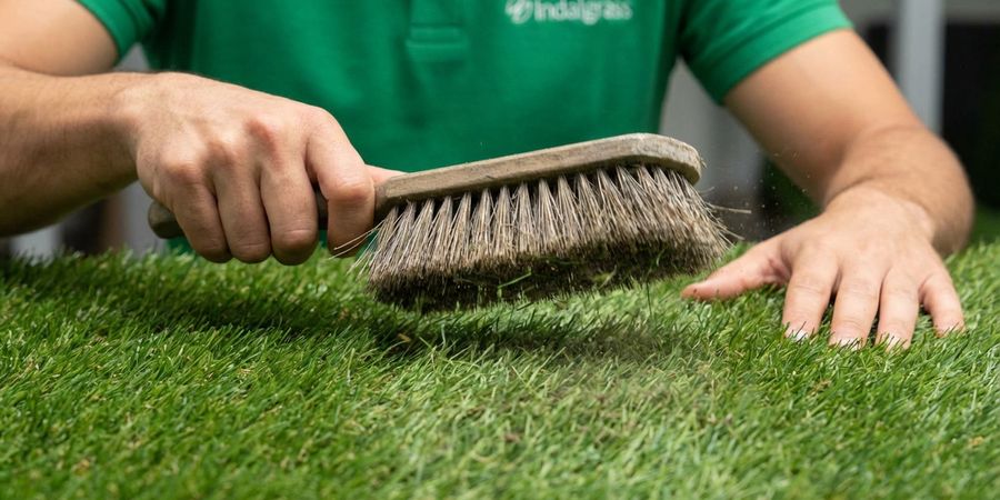 Cepillado del césped artificial para mejorar la penetración del desinfectante
