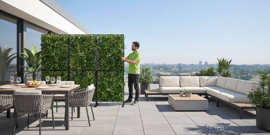 Separador de espacios con césped vertical en terraza dividiendo zonas