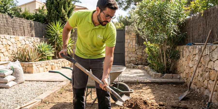 Preparación profesional del terreno con gravilla y compactación para instalación de césped artificial para perros
